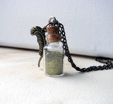 Gold Glitter Dust In A Glass Vial With A Brass Feather Charm Pendant